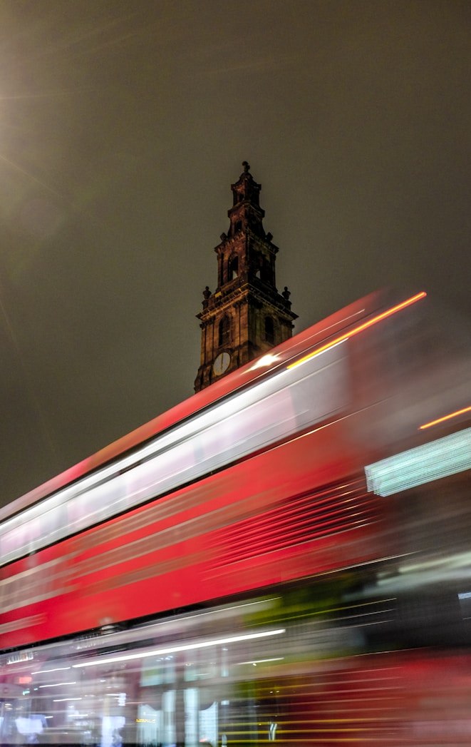 A bus passing Leeds city hall at night.